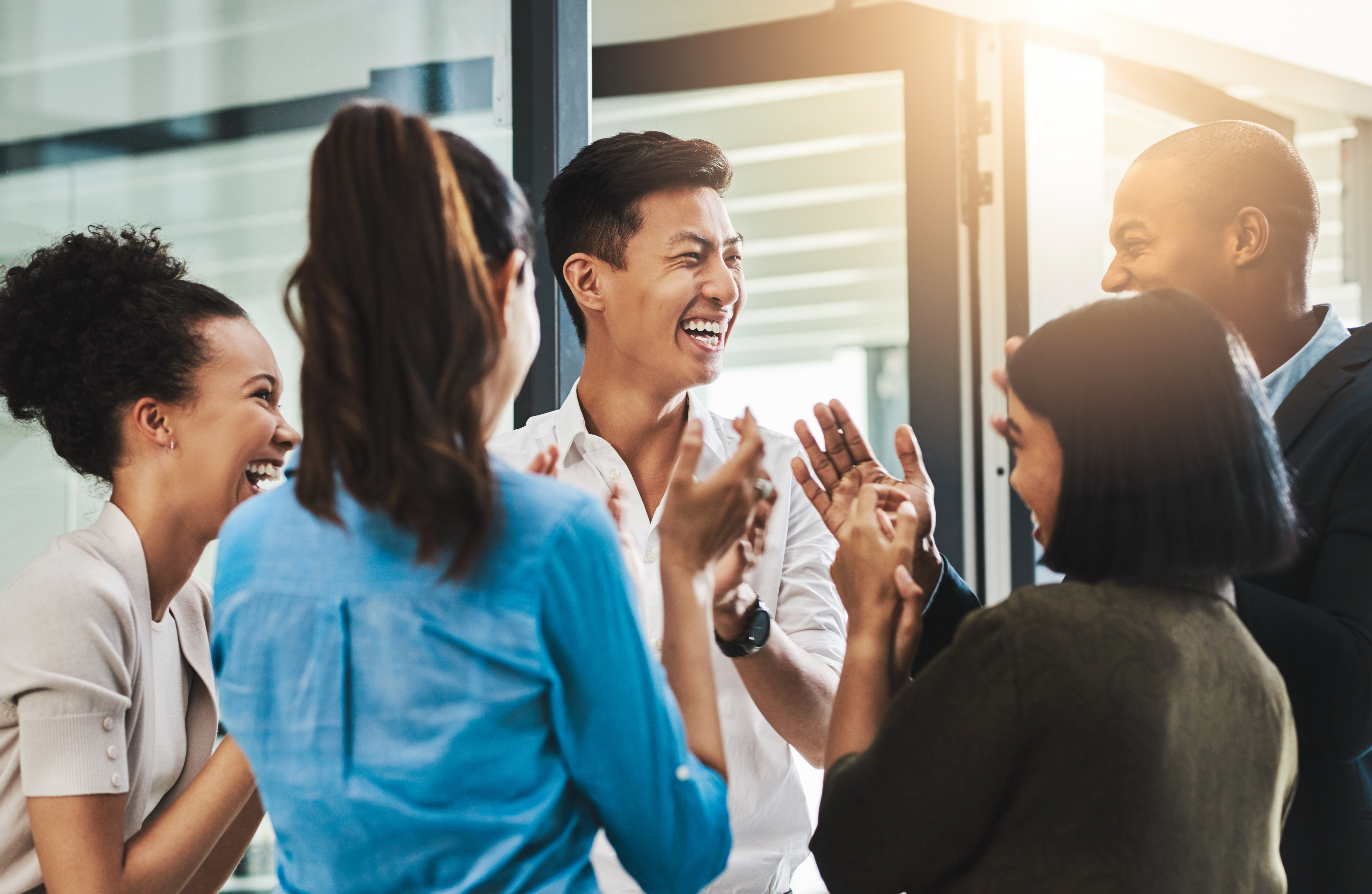 Nothing motivates productivity like team morale Shot of a group of young businesspeople standing together and clapping in a modern office