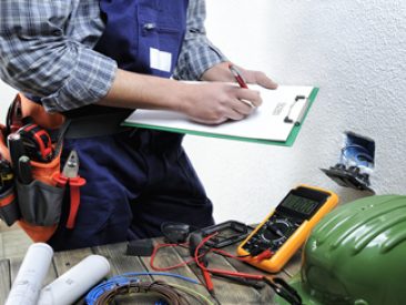 Young electrician at work on switches and sockets of a residential electrical installation.